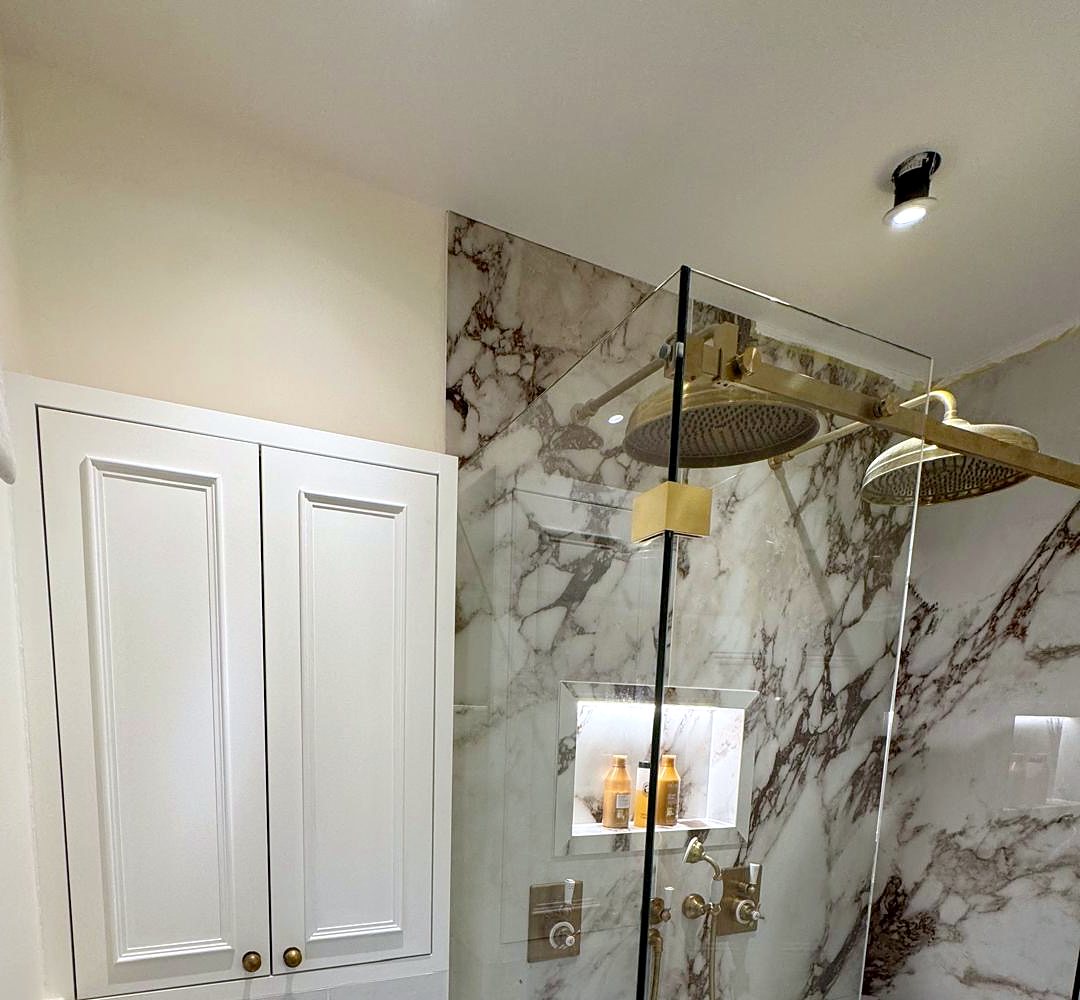 Built-in bathroom cupboard beside a marble shower