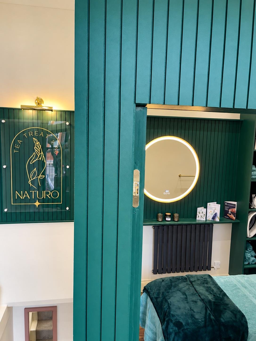Fluted green panelling with a door set into it, and the treatment room beyond